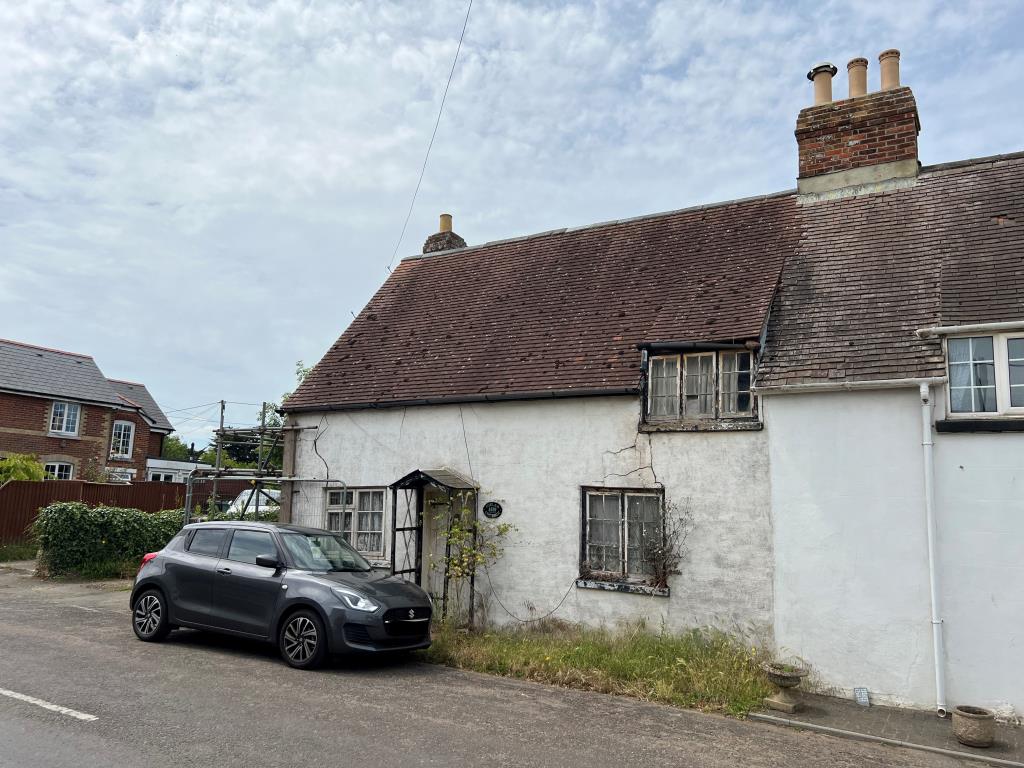 Lot: 128 - THREE-BEDROOM COTTAGE FOR IMPROVEMENT IN POPULAR VILLAGE LOCATION - A street view from the front right